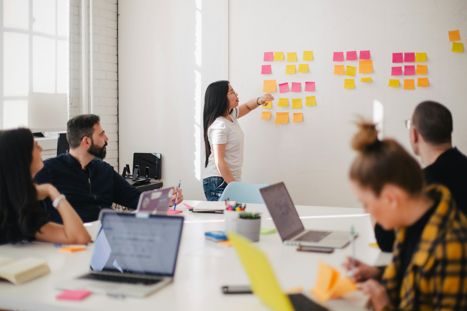 Team mapping a strategy with sticky notes on a glass wall